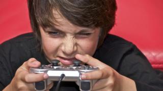 Image of a child concentrating with a games controller in his hand