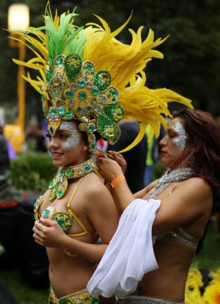 A woman in a bikini and elaborate yellow and green feathered headress and collar, in the annual Sydney Gay and Lesbian Mardi Gras festival prepares her costume in Sydney, Australia March 4, 2017