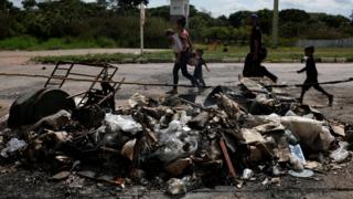 Venezolanos frente a tiendas de campaña quemadas en protesta el sábado