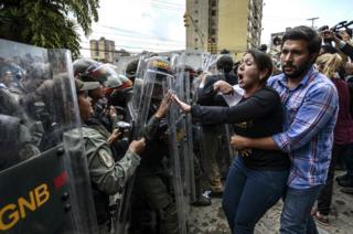 Venezuelan opposition deputy deputy Amelia Belisario (C) argues with National Guard personnel in riot gear during a protest in front of the Supreme Court in Caracas on 30 March 2017