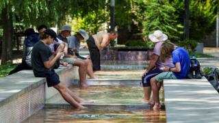 Pilgrims cool down in a fountain as they cover the Santiago Way, in Logrono, Spain,