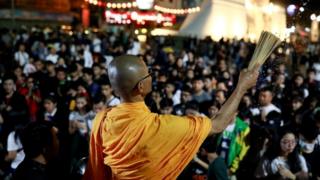 A Buddhist monk sprinkles holy water at a vigil in Nakhon Ratchasima