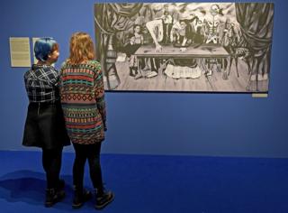 Dos mujeres miran la réplica de "La mesa herida" de Frida Kahlo en el Centro Cultural ZAMEK, en Poznań, Polonia.