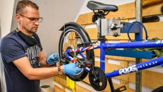 Un hombre reparando una bicicleta