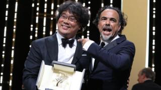 South Korean director Bong Joon-Ho (L) poses on stage with Mexican director and President of the Jury of the Cannes Film Festival Alejandro Gonzalez Inarritu after he was awarded with the Palme d