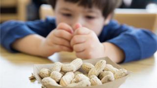 Niño comiendo maní.