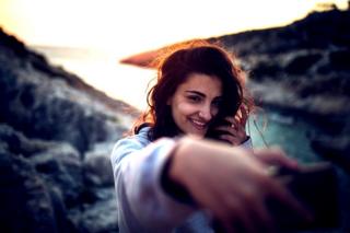 Mujer tomándose un selfie al atardecer.