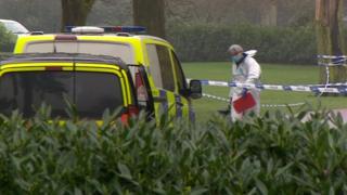 A forensic officer within the police cordon