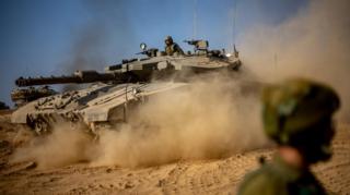 Israeli forces with battle tanks muster at a gathering site at an undisclosed location along the border with Gaza