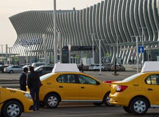 SIMFEROPOL, RUSSIA - APRIL 16, 2018: Taxi cars outside the new passenger terminal building at the Simferopol Airport in Simferopol, Crimea, Russia