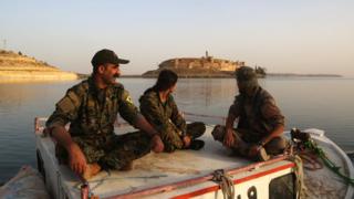Members of the US-backed Syrian Democratic Forces look towards Jaabar Castle from a boat on Lake Assad, a reservoir created by the Tabqa dam. April 29, 2017