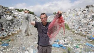 Hugh Fearnley-Whittingstall holding up plastic waste at a dump in Malaysia