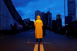 A protester wears a yellow raincoat to pay tribute to a man who died while protesting