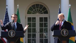 Imagem mostra Bolsonaro, à esquerda, e Donald Trump em discurso na Casa Branca