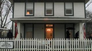 Bill Clinton (right) holds an umbrella under the porch of his childhood home in Hope, Arkansas. File photo