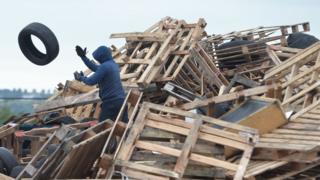 Tyres being removed from a bonfire at Avoniel in east Belfast on Monday