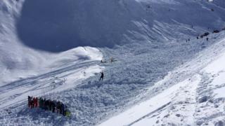 Des secouristes fouillent la neige abattue par l'avalanche