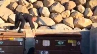 Полицейский открывает мусорный контейнер