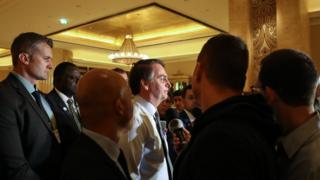 Bolsonaro aparece de perfil falando com jornalistas de dentro de hotel em Abu Dhabi