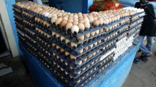 An egg vendor sits behind his stall 28 April 2005 in Dakar's Castore market
