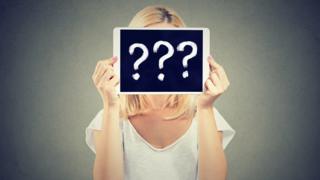 A face covered by question marks