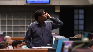 A Pakistani stockbroker watches share prices on monitor during a trading session at the Pakistan Stock Exchange (PSX) in Karachi