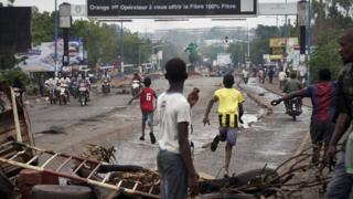 People run away at the arrival of the riot police as protesters set barricades in Bamako
