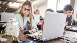 Школярі сидять у класі за комп'ютерами