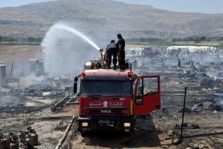 Bomberos apagan el fuego en un campamento de refugiados sirios en el valle de Bekaa, en Líbano.