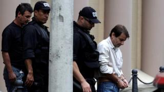 Em foto de 2009, Battisti aparece escoltado por policiais federais