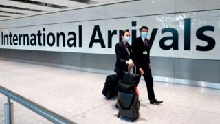 British Airways flight crew wearing masks walk through Heathrow Airport