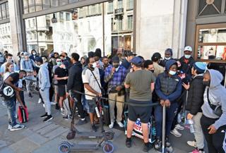 A group of shoppers queue outside a Nike store in London