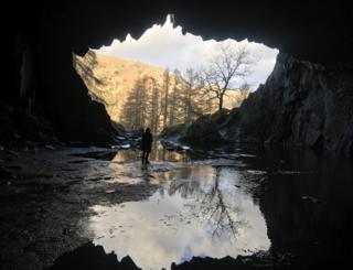 A cave silhouette against landscape