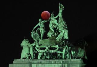 The moon seen beside a quadriga on top of the Cinquantenaire arch in Brussels