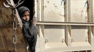 A young girl in the back of a truck being evacuated out