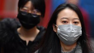 Pedestrians wear surgical masks in London's China Town on January 24, 2020