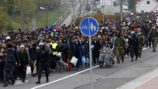 Slovenian police and army escort migrants from the train station to a registration point in the village of Sentilj, Slovenia, October 28, 2015