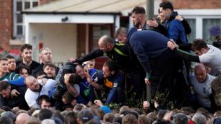 Players fight for the ball during the annual Shrovetide football match in Ashbourne