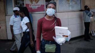 A woman sells surgical mask on the streets in Nairobi for 200 shillings each