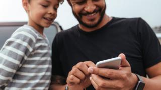 padre e hijo usando celular