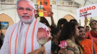 मोदी के बैनर के आगे महिलाएं