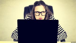 woman with laptop looking suspicious