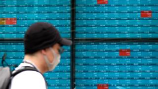 Man walks past market boards in Tokyo.