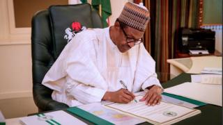 Aarẹ Buhari n buwọlu iwe kan