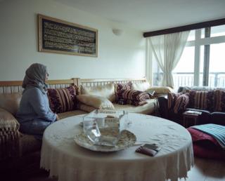 Fatouma sits in her flat