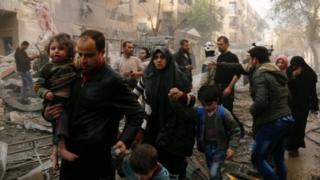 Syrians make their way through debris as they leave for a safer place part of Aleppo in this January 2016 file picture