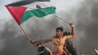 Sawir laga qaaday Isniintii Falastiini gacan calan ku haysta ta kalena wadhaf ku lalinaya