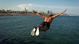 Leute springen ins Wasser in Barcelona, ​​Spanien