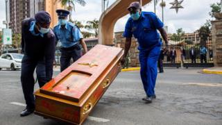 Kenyan police officers remove an empty coffin left after the protest against police brutality in Nairobi on June 9, 2020.