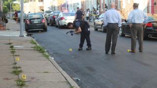 Can this US city go 72 hours without a murder? 9 Baltimore police detectives on the scene of a homicide in the Pigtown neighbourhood